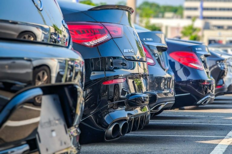 Reihe von glänzenden schwarzen Autos mit sportlichen Auspuffanlagen.